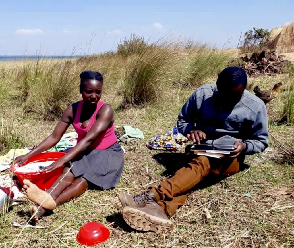 University of Zambia student Robert K. Sakapaji conducts a survey with a mother from a fishing village on Lake Bangweulu